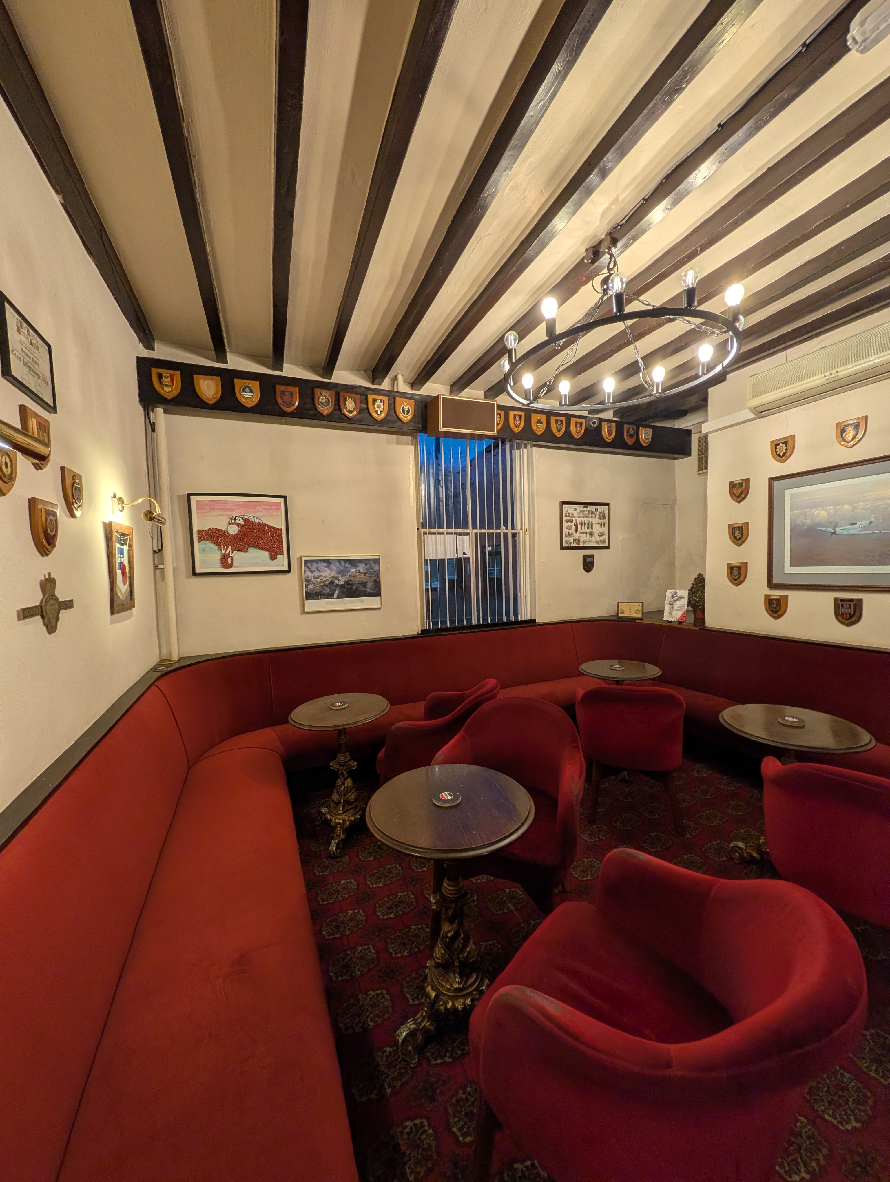 The lounge with red seating under a beamed ceiling