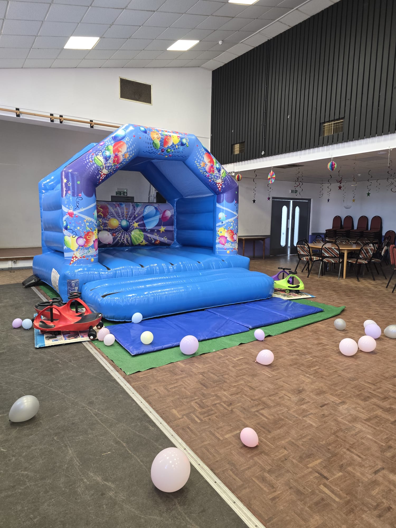 A blue bouncy castle set up in the function room for a children’s party
