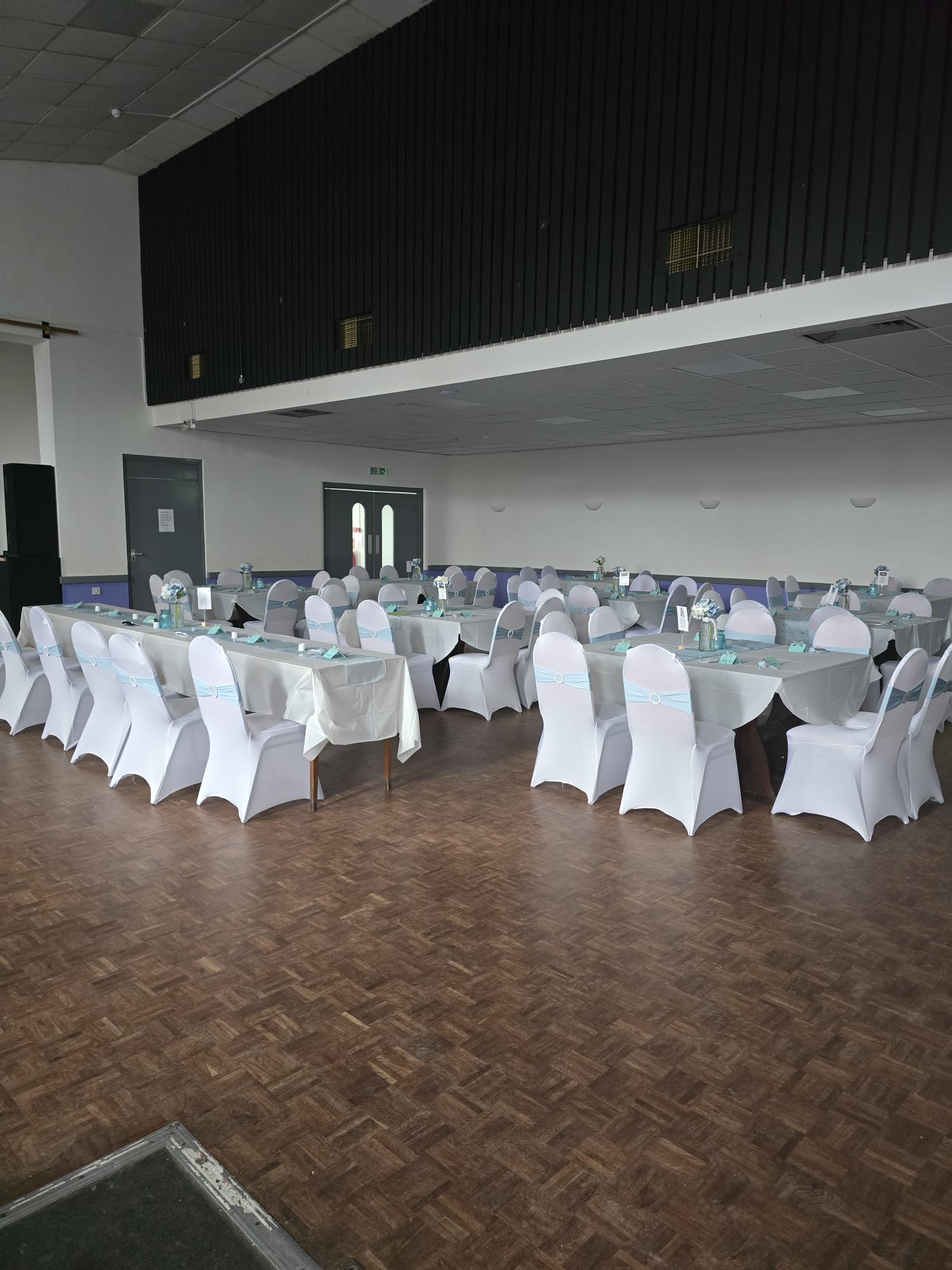 The function room dressed for a wedding with white chair covers